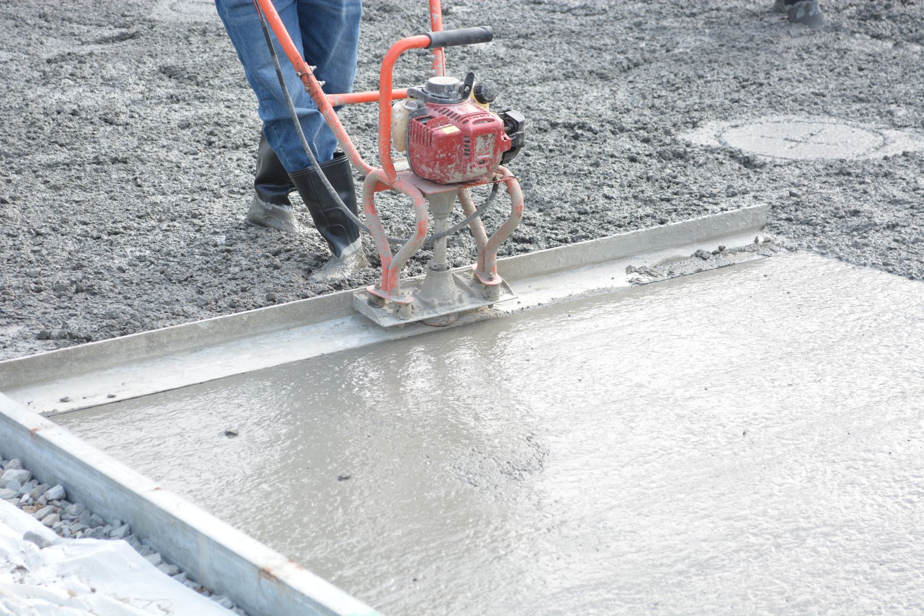 Power trowel smoothing a concrete surface