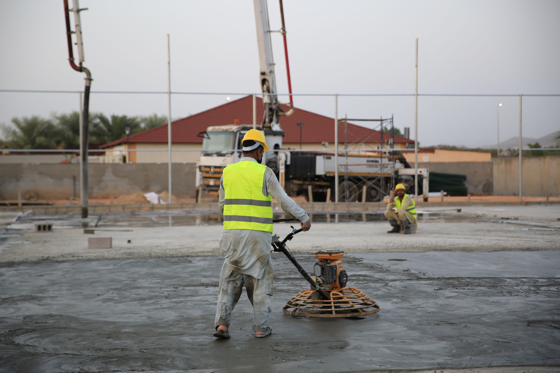 Workers smoothing a concrete slab